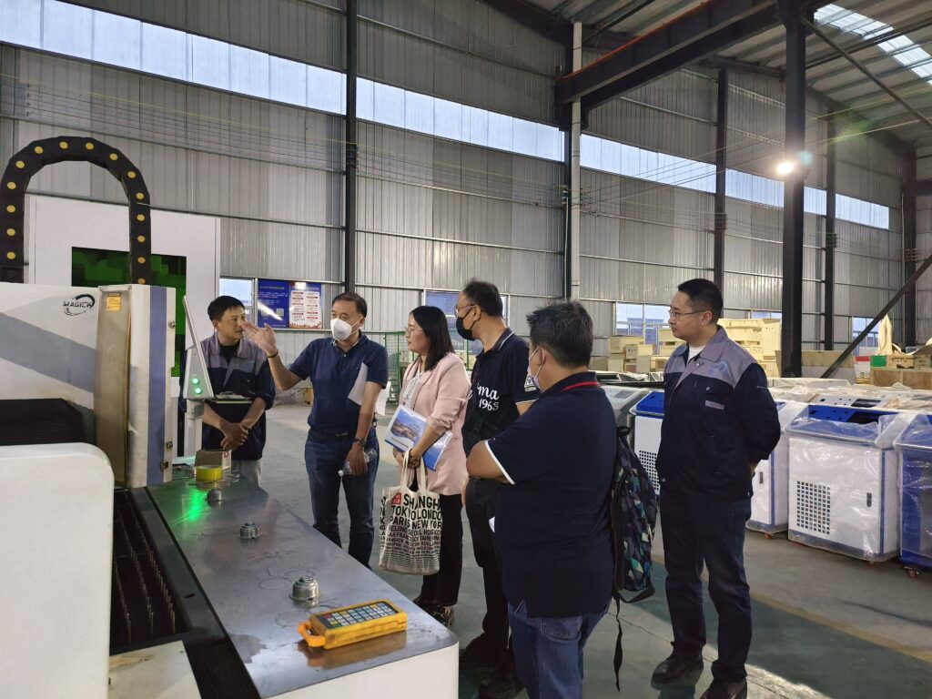 International B2B clients evaluating a Magick fiber laser cutting machine during a factory tour.
