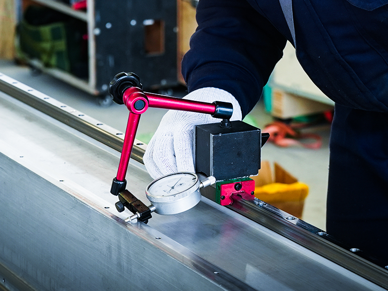 Workers are using dial indicators to accurately calibrate the rails.