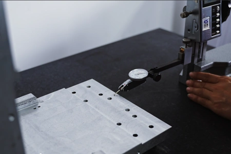 MAGICK technician checking chuck alignment and positioning accuracy on a tube laser cutting machine
