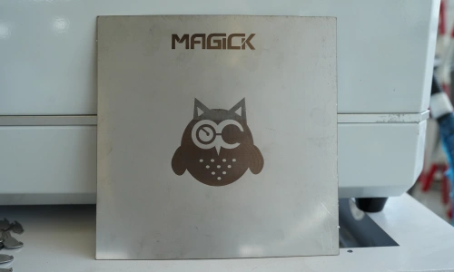 Laser-cut metal sign sample featuring the MAGICK logo and an owl graphic