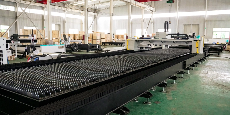Factory view along the MK-H laser cutting bed showing its extended support slats, side guideway covers and gantry
