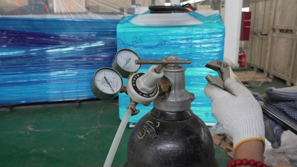 Technician adjusting an oxygen cylinder pressure regulator with a wrench in a laser cutting machine workshop